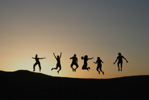 夕日を背景に飛び上がる人達